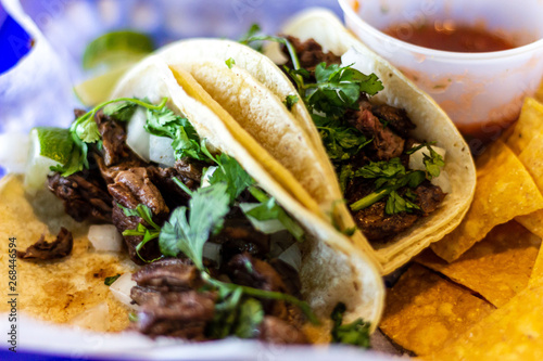 Two carne asada tacos with cilatro and onion on corn tortillas. photo