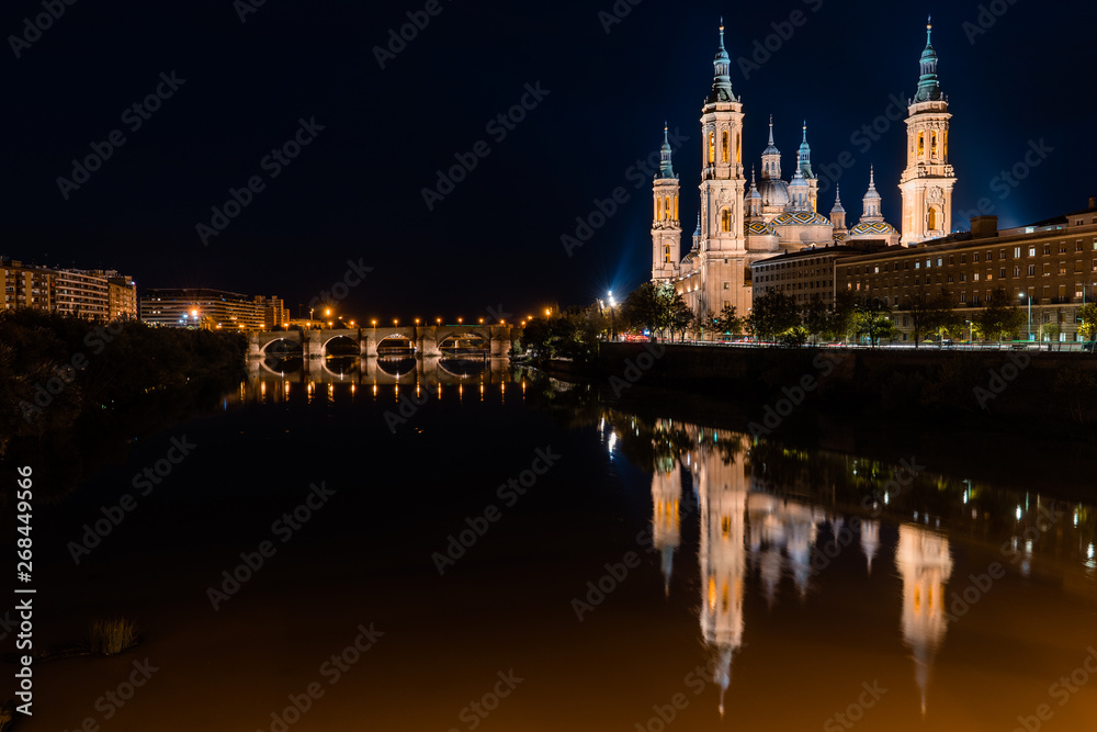 Cathedral-Basilica of Our Lady of the Pilar in Zaragoza, Spain with a reflection on the river and the bridge that cross it