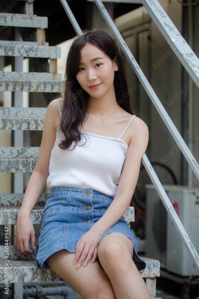 Portrait of thai china adult beautiful girl White shirt blue jeans relax and smile