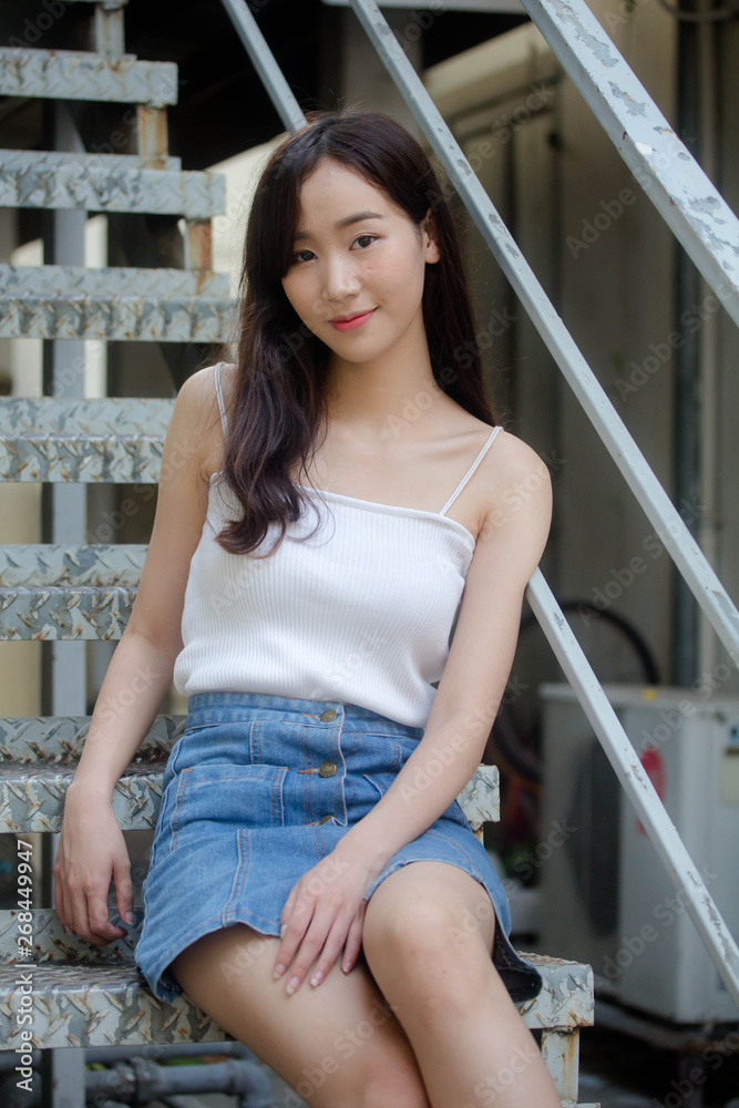 Portrait of thai china adult beautiful girl White shirt blue jeans relax and smile Portrait of thai china adult beautiful girl White shirt blue jeans relax and smile