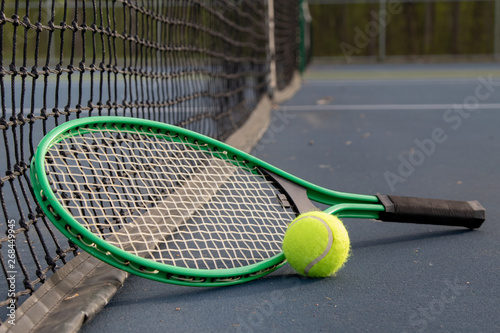 Close up of tennis ball and racket on court from the prospective of the net © Don Mroczkowski
