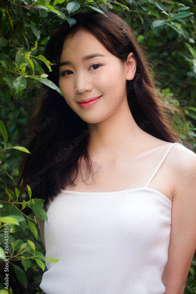 Portrait of thai china adult beautiful girl White shirt blue jeans relax and smile Portrait of thai china adult beautiful girl White shirt blue jeans relax and smile