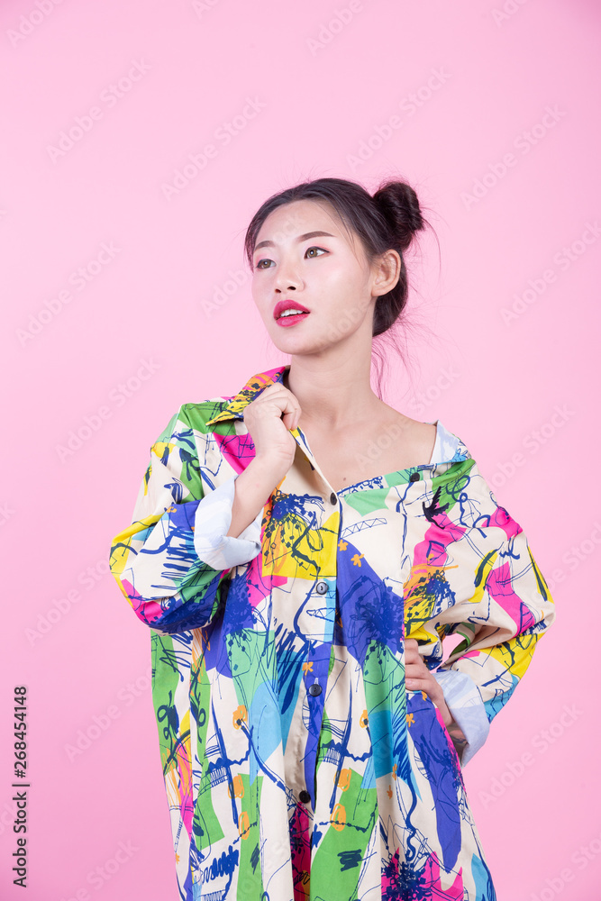 Fashion girl dress up with hand gestures on a pink background. Fashion girl dress up with hand gestures on a pink background.