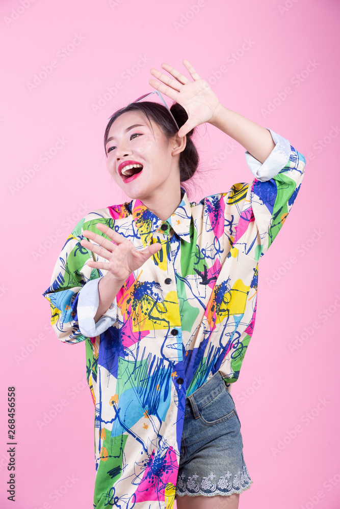 Fashion girl dress up with hand gestures on a pink background. Fashion girl dress up with hand gestures on a pink background.
