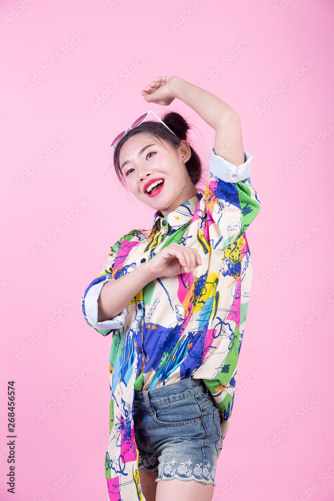 Fashion girl dress up with hand gestures on a pink background. Fashion girl dress up with hand gestures on a pink background.