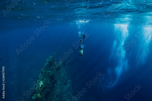 Freediver man dive underwater at shipwreck in Bali. Freediving in ocean
