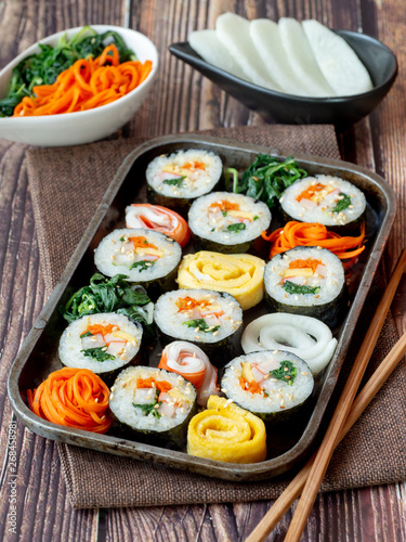 Set of kimbub or sushi roll in steel plate ready to serve in korean style menu with chopstick.
