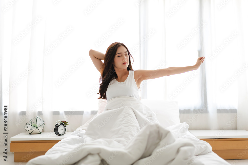Woman stretching happy and relaxed after wake up in the morning at home Woman stretching happy and relaxed after wake up in the morning at home