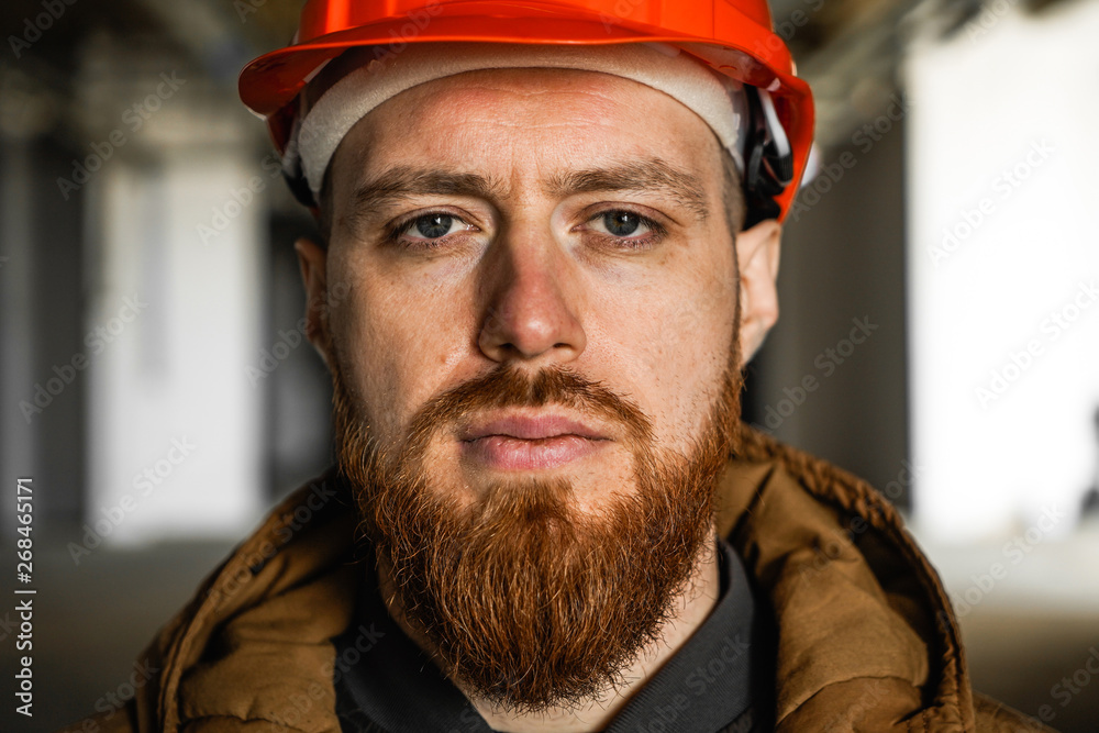 The average plan portrait of an adult man in a helmet with redhead, evaluates, studies, looks into the frame, horizontal, close up The average plan portrait of an adult man in a helmet with redhead, evaluates, studies, looks into the frame, horizontal, close up