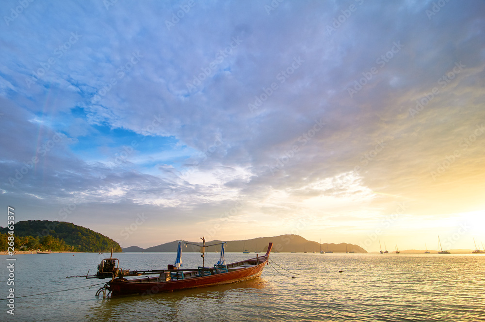 Travel in Thailand.  Colorful landscape with sea beach, traditional longtail boat over beautiful sunset background.