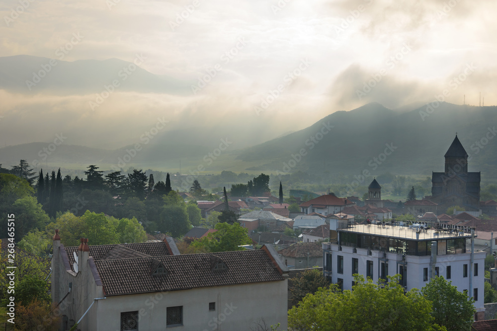 Mtskheta - ancient capital of Georgia. Top view of old town with Svetitshoveli Cathedral in morning backlit Mtskheta - ancient capital of Georgia. Top view of old town with Svetitshoveli Cathedral in morning backlit