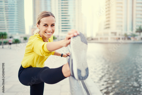 Healthy lifestyle. Young woman exercising on city embankment.