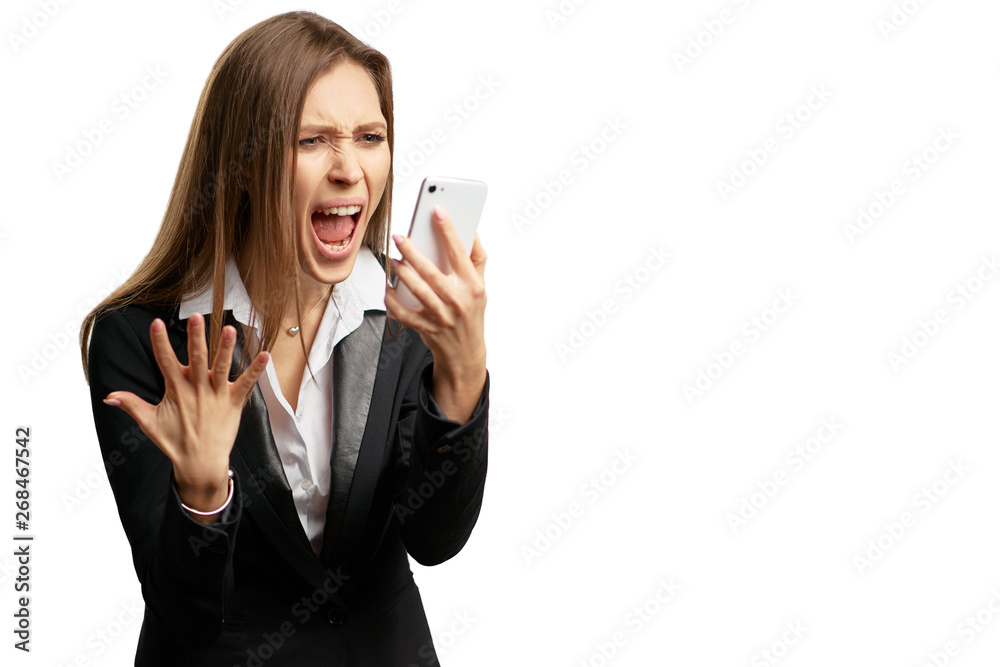 Stressful phone talk. Furious young businesswoman in suit shouting at cellphone while standing isolated on white. Stressful phone talk. Furious young businesswoman in suit shouting at cellphone while standing isolated on white.
