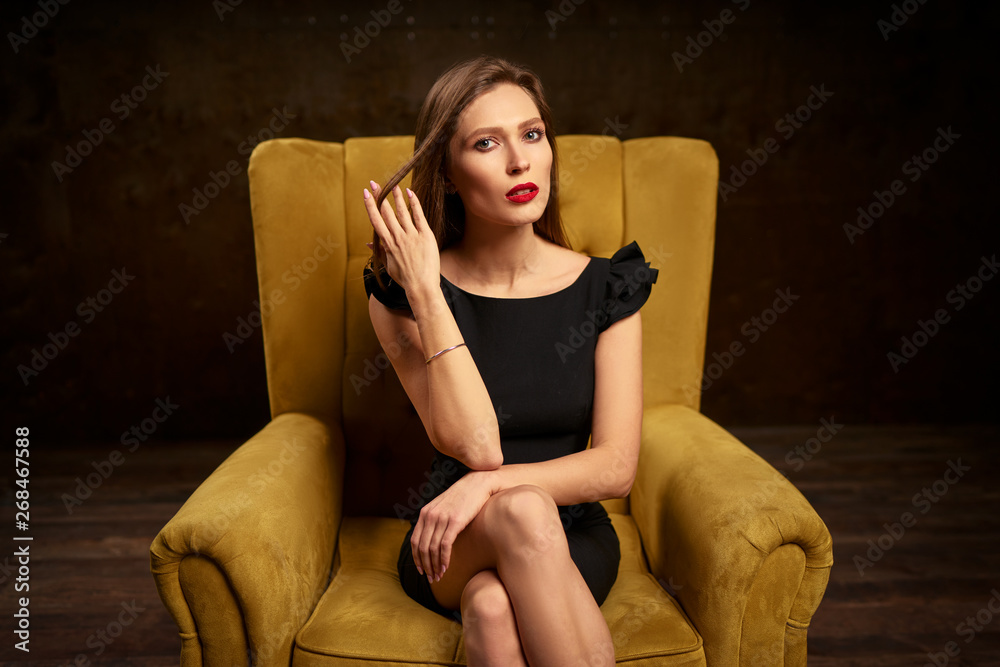 Portrait of a stunning fashionable model sitting in a chair. Business, elegant businesswoman. Portrait of a stunning fashionable model sitting in a chair. Business, elegant businesswoman.