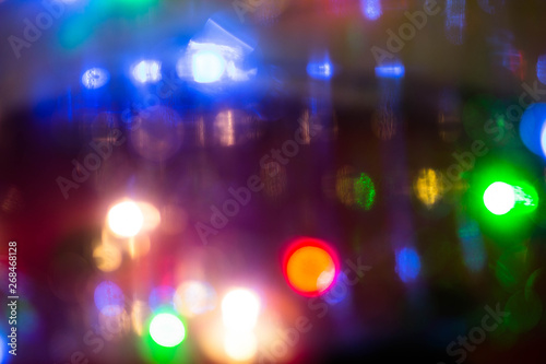 Blurred colored lights. Bright round multi-colored spots, background and pattern for design. Texture of colorful lanterns in the background. © Daniil