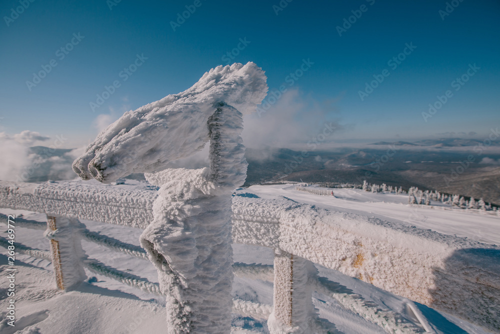 Frozen, snow covered touristic binocular in mountain top. Cold winter in North, view coin operated binoculars