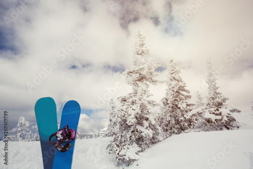 Two snowboards in winter spruce forest, frozen mountain landscape, deep snow, frost on the trees