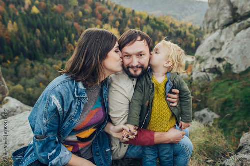 Happy family: mother father and child in mountains. 