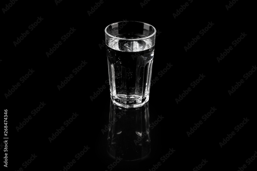 Glass of pure mineral water, refreshing fresh water over black background Glass of pure mineral water, refreshing fresh water over black background