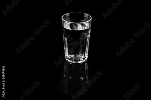 Glass of pure mineral water, refreshing fresh water over black background