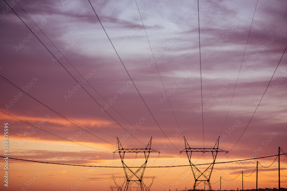 Landscape view of electric pylon during sunset
