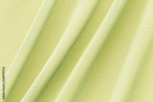 yellow fabric with large diagonal folds, delicate background