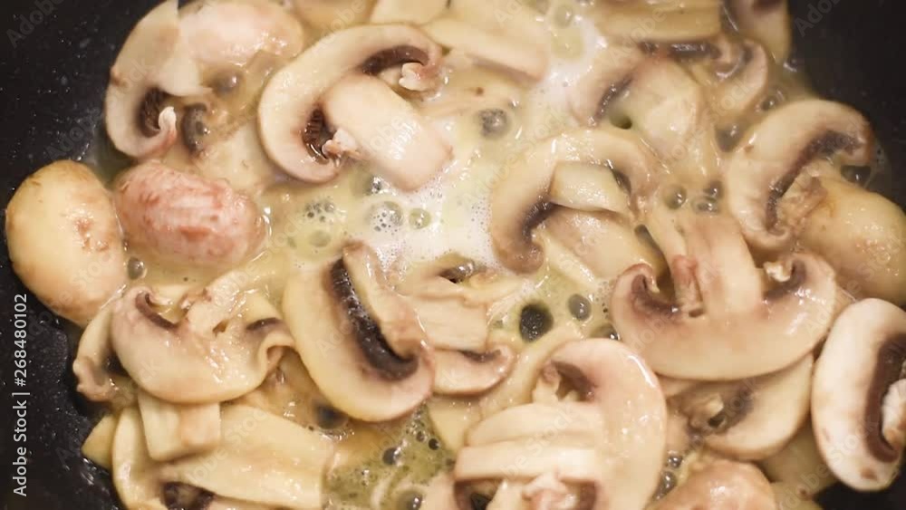 Mushrooms, fried in a pan in heated butter with onions and pepper. Mushrooms in the process of stewing and frying in a pan in butter Mushrooms, fried in a pan in heated butter with onions and pepper. Mushrooms in the process of stewing and frying in a pan in butter