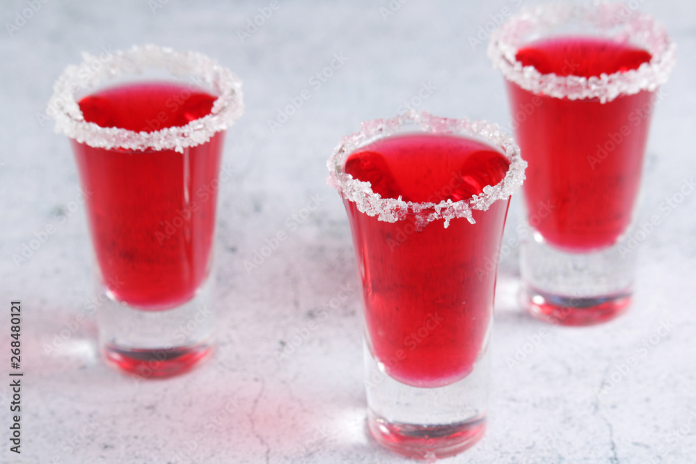 Three cranberry liquor shots with whole berries Three cranberry liquor shots with whole berries