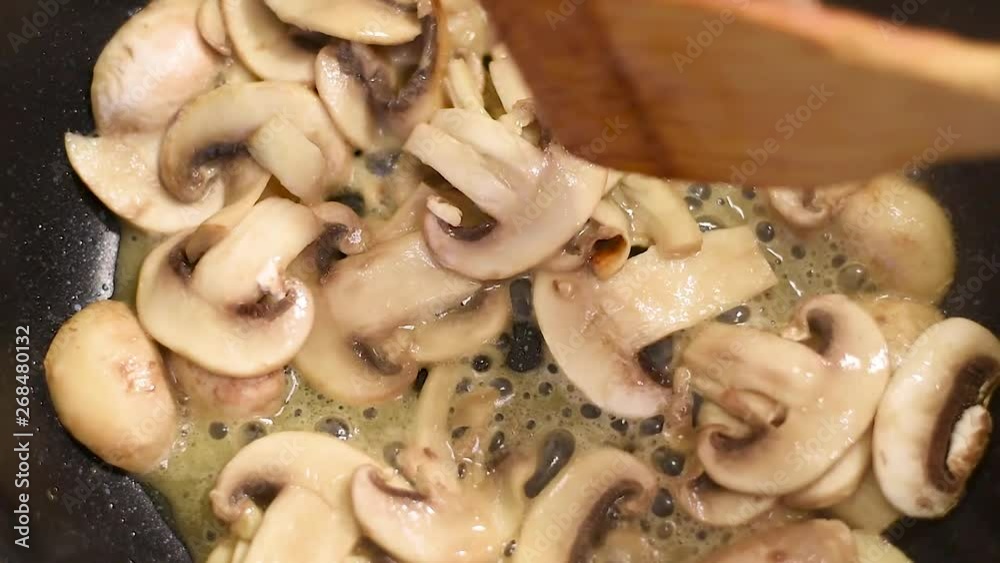 Mushrooms, fried in a pan in heated butter with onions and pepper. Mushrooms in the process of stewing and frying in a pan in butter Mushrooms, fried in a pan in heated butter with onions and pepper. Mushrooms in the process of stewing and frying in a pan in butter