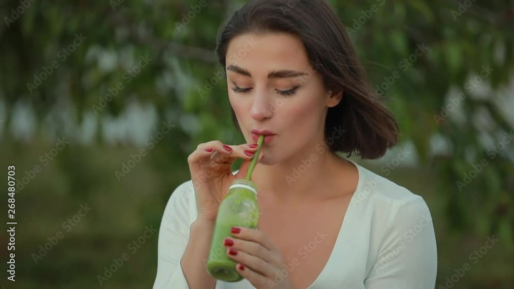 Beautiful woman drinking smoothie outdoor, healthy food, detox concept Beautiful woman drinking smoothie outdoor, healthy food, detox concept