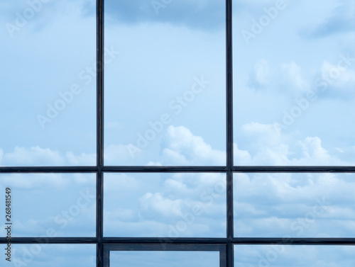 Window frame and blue sky with clouds. Outside the office window.