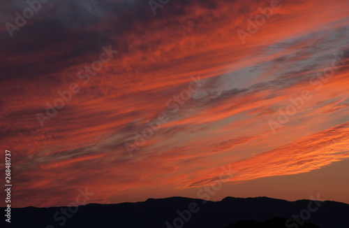 Beautiful evening sky. Clouds lit up in fiery red by the setting sun.