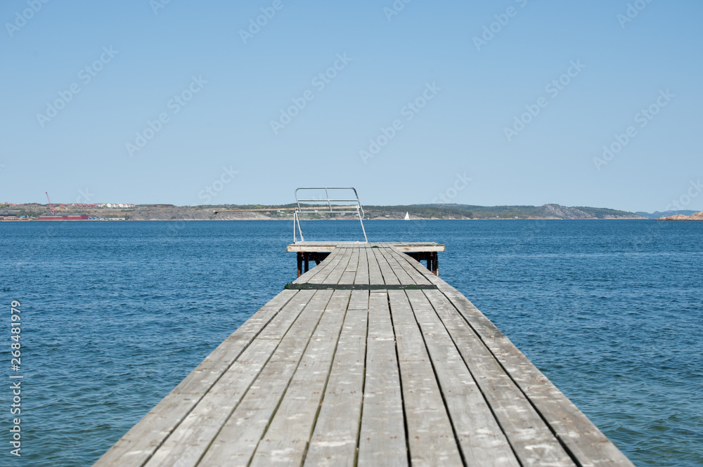 Obraz premium Wooden pier with a spring board waiting for the summer to arrive.