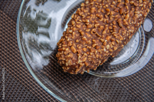 Tasty chocolate cake with nuts on a saucer. Top view