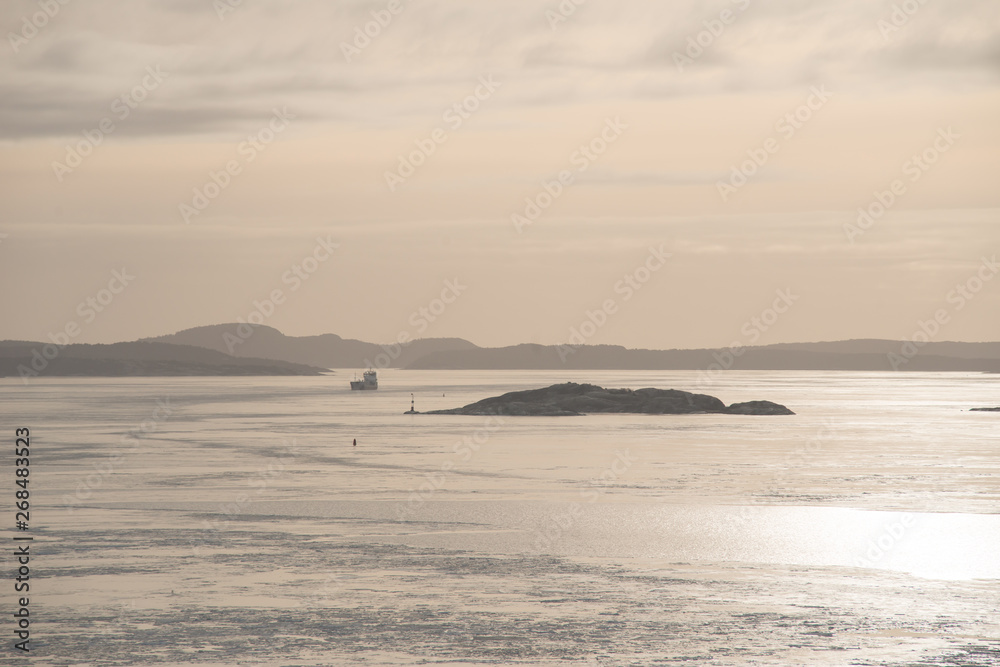 A ship sailing in a cold fjord in rhe winter. A ship sailing in a cold fjord in rhe winter.