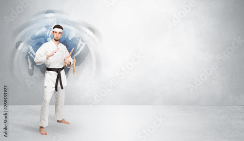 Young businessman in suit fighting with empty wall background 