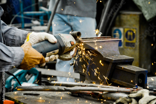 Worker are grinding metal steel, Electricity spark from chainsaw, Technician are cutting pipe, Risk work for electricity in factory