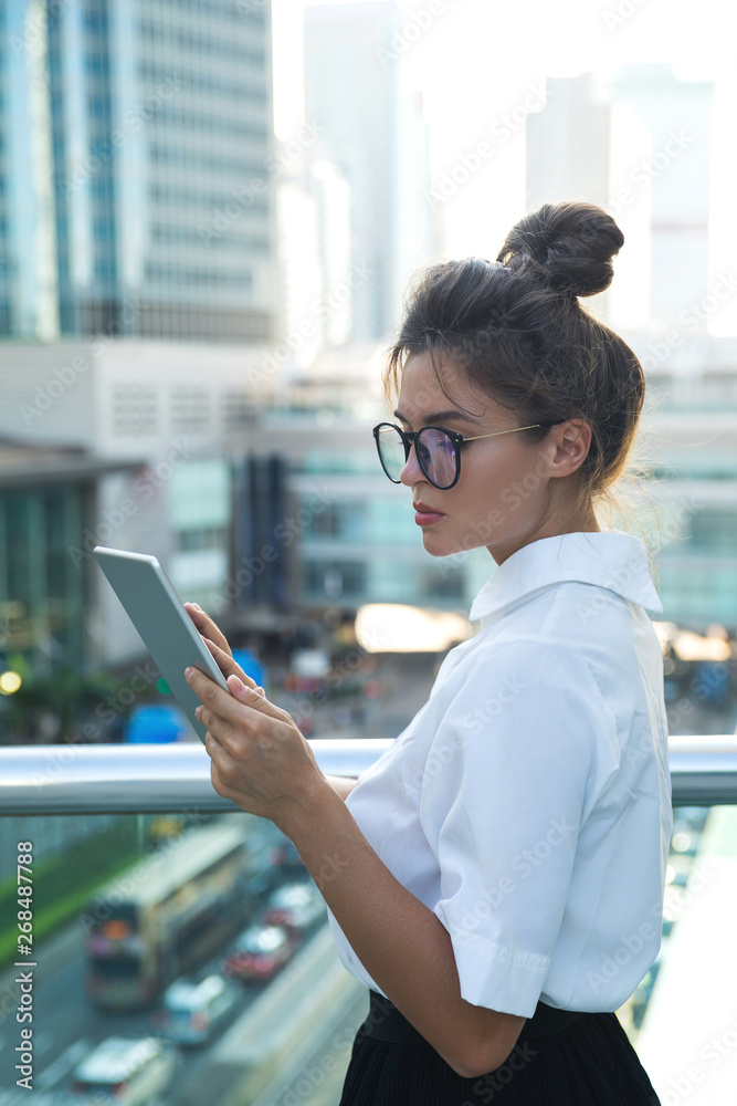 Woman wearing smart casual clothing  is using tablet pc