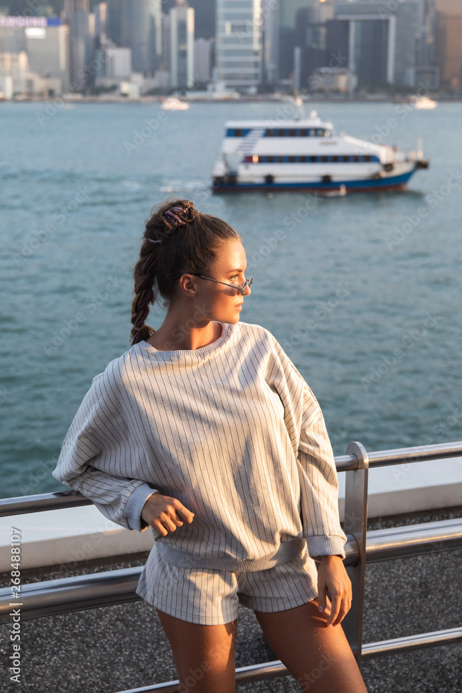 Stylish woman is posing in the Victoria Harbour, Hong Kong city. Stylish woman is posing in the Victoria Harbour, Hong Kong city.