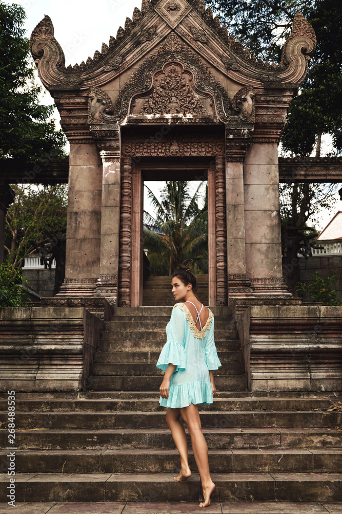 Young woman posing beside ancient Khmer ruins