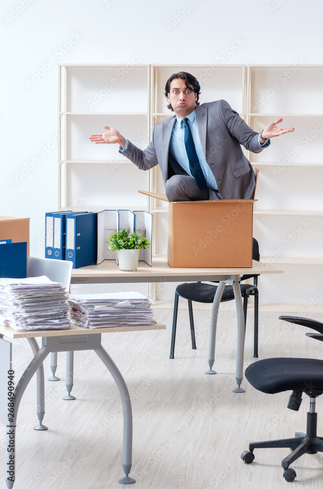 Young man employee with boxes in the office Young man employee with boxes in the office