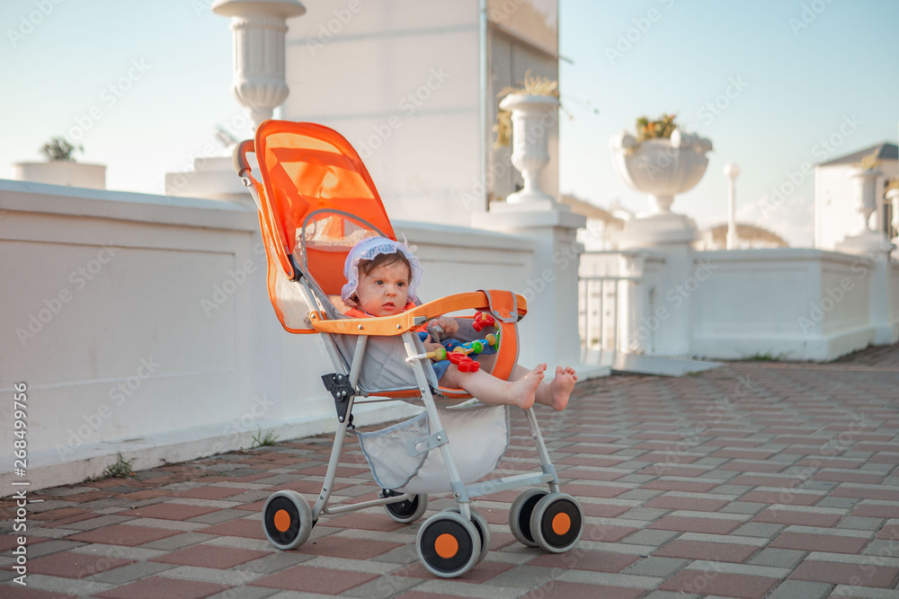 Little girl in a stroller by the sea. In a headdress. Little girl in a stroller by the sea. In a headdress.