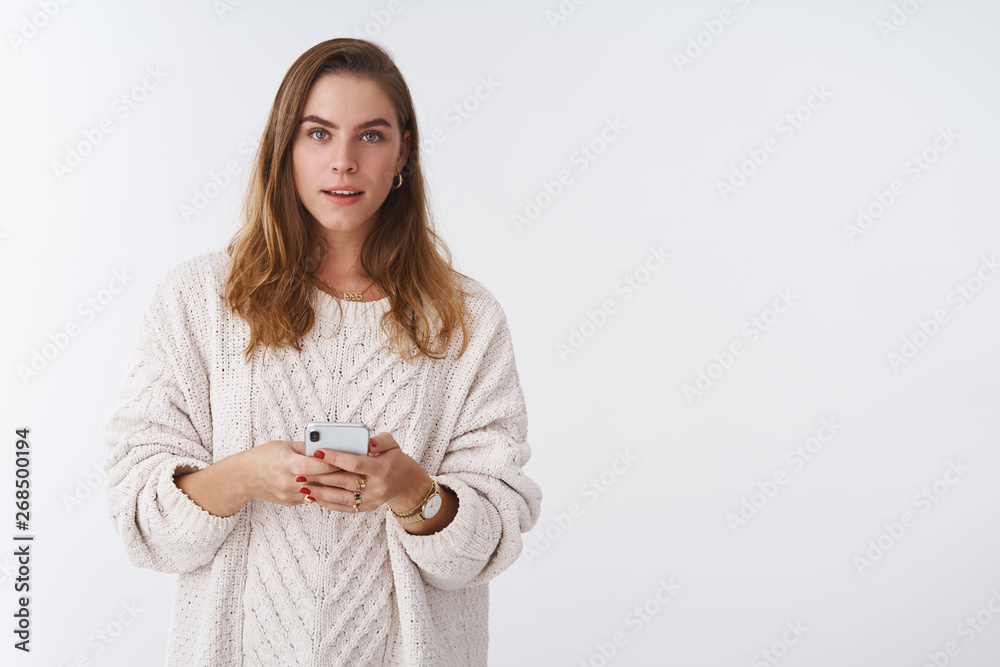 Waist-up shot curious cute casual modern attractive woman short haircut wearing loose trendy cozy sweater holding smartphone listening you consulting how answer message dating app Waist-up shot curious cute casual modern attractive woman short haircut wearing loose trendy cozy sweater holding smartphone listening you consulting how answer message dating app