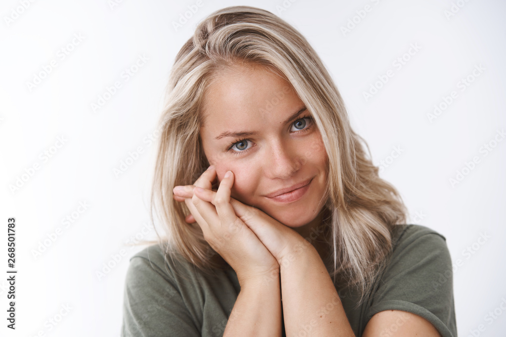 Tenderness, romance and sensuality concept. Lovely good-looking european blond leaning on palms smiling flirty and gazing at camera with sympathy and cheeky grin, posing over white background Tenderness, romance and sensuality concept. Lovely good-looking european blond leaning on palms smiling flirty and gazing at camera with sympathy and cheeky grin, posing over white background