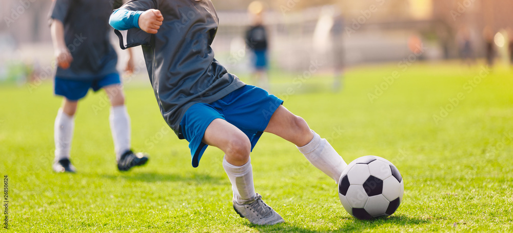 Child kicking soccer ball. Kid make an effective soccer shooting Child kicking soccer ball. Kid make an effective soccer shooting