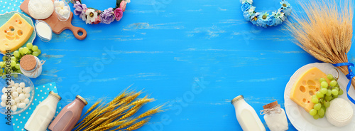 top view photo of dairy products over blue wooden background. Symbols of jewish holiday - Shavuot photo