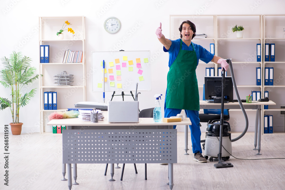 Fototapeta premium Male handsome professional cleaner working in the office 