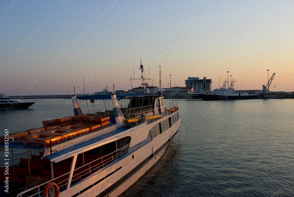 Fototapeta premium Navy pier and dock. White boats and ships. Twilight sunset sky. Beautiful water. Warm summer.