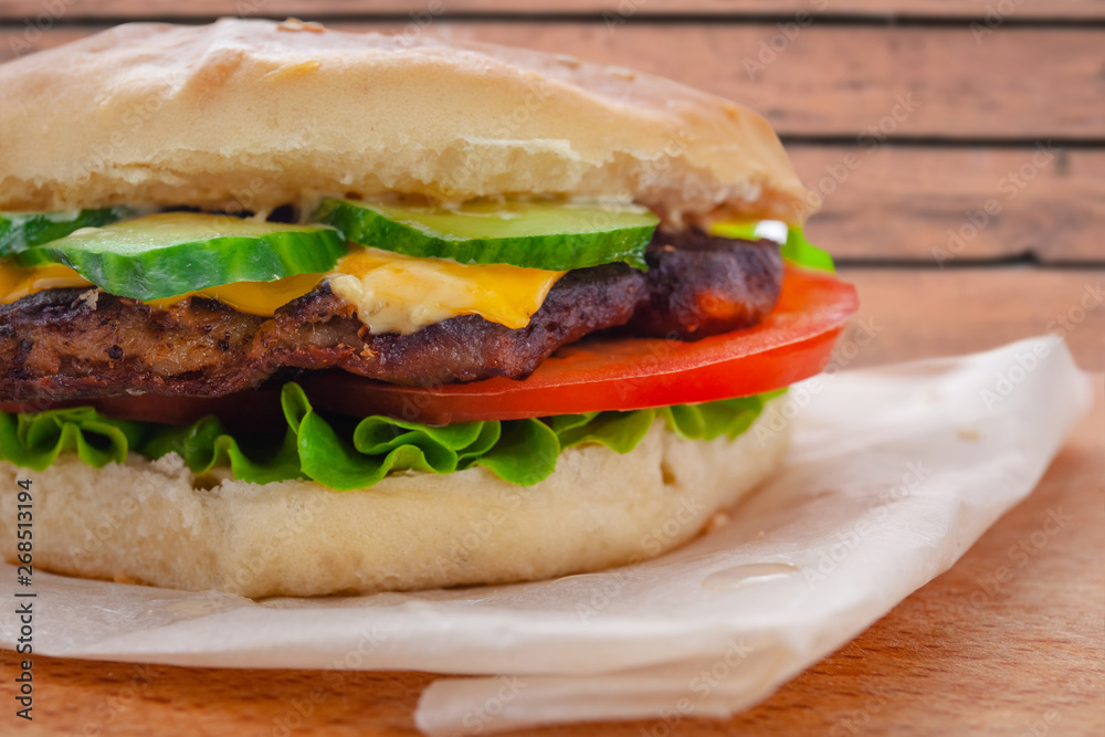fresh flavored cheeseburger with juicy cutlet, cucumbers, tomato and lettuce