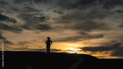 Senior female traveller standing against sunset